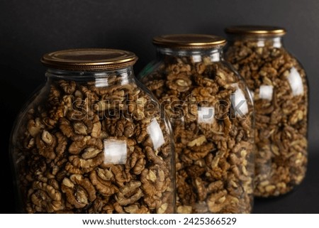 The walnut kernels in jar isolated on dark background
