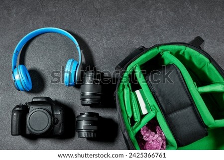 Professional Photography Gear : camera and lenses, blue wireless headphone on grunge gray background