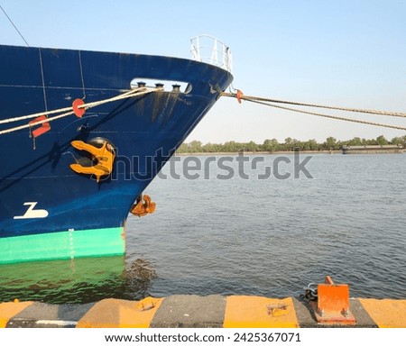 Anchor, close-up of a large cargo ship's anchor being pulled. While docked at the pier on the Chao Phraya River, Bangkok, in the background is a view of the blue sky and transportation concept