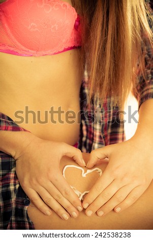 Skincare. Closeup of female body with heart shaped cream. Young woman girl taking care of her dry legs skin applying moisturizer lotion. Beauty treatment.