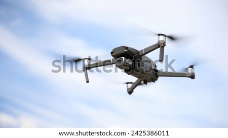 Close-up of digital camera on drone with remote control. Modern copter flying in sky. Shooting propeller option. Technology and innovation concept Royalty-Free Stock Photo #2425386011