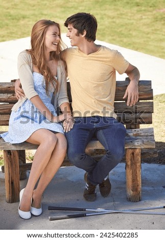 Smile, love and couple on bench in nature on a valentines day, anniversary or romantic date. Happy, connection and young man and woman embracing, sitting and bonding together in outdoor park. Royalty-Free Stock Photo #2425402285