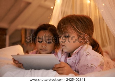 Girls, tablet or games on bed at night, playing or digital technology for cartoons with love in home. Young kids, friends or connection by fairy light, tent or streaming video for bonding together