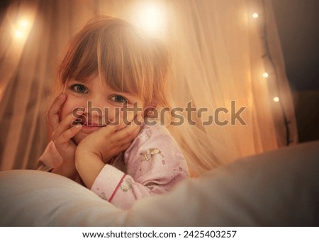 Bed, lights and portrait of child at night for resting, relaxing and dreaming in home. Happy, smile and face of young girl with fairy light decoration in bedroom for fantasy, magic and childhood Royalty-Free Stock Photo #2425403257