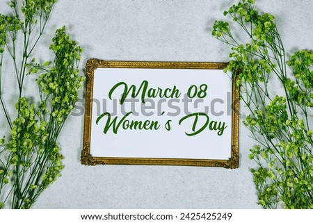 happy women's day on golden picture or photo frame mockup with green baby's breath, gypsophila on gray grunge background