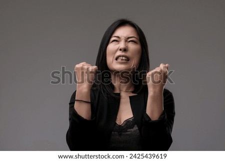 Woman in a moment of peak exasperation, her clenched hands expressing profound annoyance Royalty-Free Stock Photo #2425439619