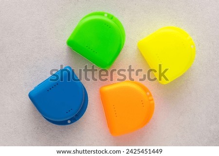 Multi-colored containers for dental plates. Box for orthodontic mouthguard Royalty-Free Stock Photo #2425451449