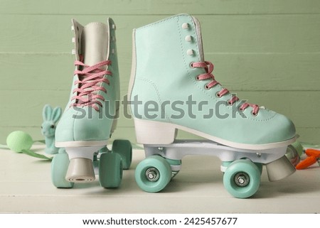 Vintage roller skates with Easter egg and toy bunny on white wooden table