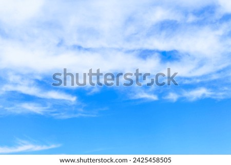 Blue sky background with white clouds, similar to fog covering mountains and waves in the sea. Royalty-Free Stock Photo #2425458505