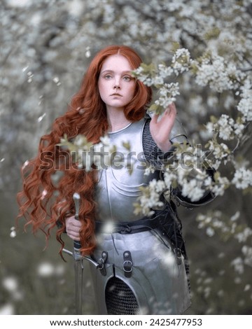 Portrait of a red-haired knight girl with developing hair in a spring blooming garden