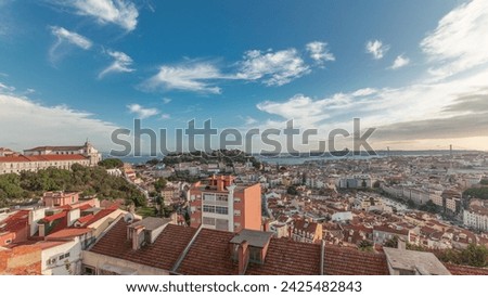 Panorama showing Lisbon famous aerial view from Miradouro da Senhora do Monte highest viewpoint of Alfama and Mauraria old city district timelapse, 25th of April Bridge before sunset. Lisbon, Portugal Royalty-Free Stock Photo #2425482843