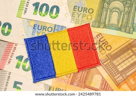 Euro banknotes and Romanian flag Concept, Conversion of Romanian lei to euro, Adoption of the common European currency by Romania Royalty-Free Stock Photo #2425489781