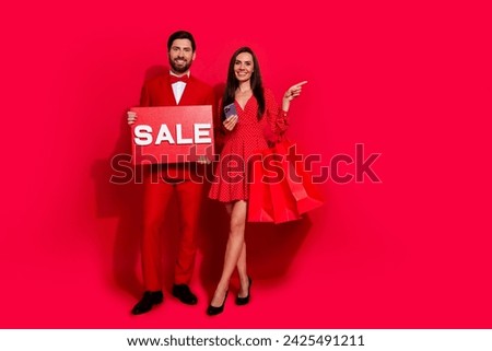Full length portrait of two classy attractive people hold sale poster smart phone direct finger empty space isolated on red color background