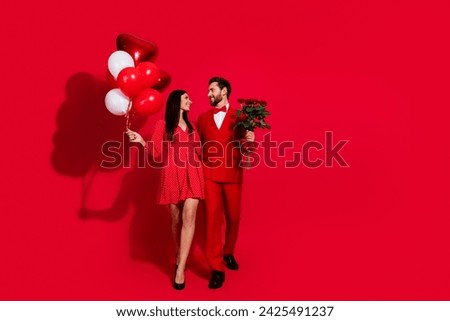 Full size photo of lovely young couple care look each other valentine day dressed stylish elegant outfit isolated on red color background
