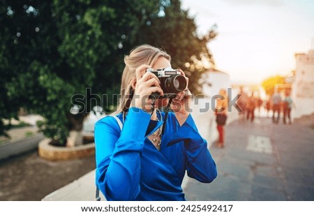 A woman tourist takes photographs of the sights in the old town.