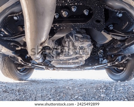 Automatic transmission oil pan of the car view from below. Mechanic wide view from below. Vehicle transmission repair and service in garage. Oil or fluid and filter change of the car transmission. Royalty-Free Stock Photo #2425492899
