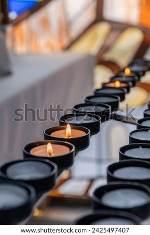  Candles for religious prayers inside a church Royalty-Free Stock Photo #2425497407