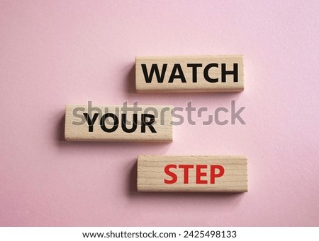 Watch your Step symbol. Concept words Watch your Step on wooden blocks. Beautiful pink background. Business and Watch your Step concept. Copy space.
