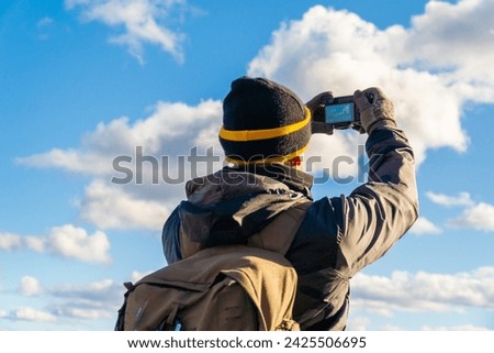Unrecognizable hiker taking photos with a DSLR camera, outdoors.