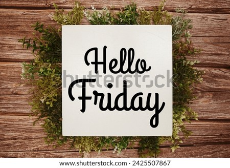 Hello Friday text message with green leaves decoration on wooden background