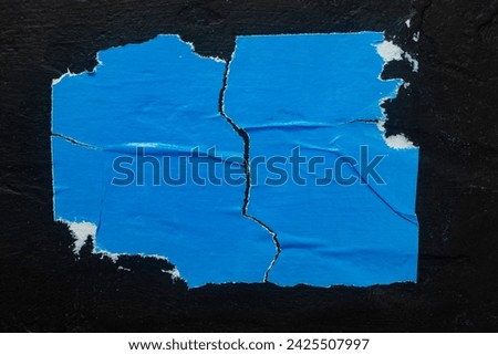 Old blue torn poster close-up. Royalty-Free Stock Photo #2425507997