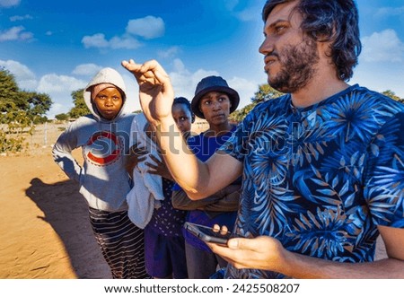 village, african teenagers and baby, community outreach program ,NGO volunteer working, education program Royalty-Free Stock Photo #2425508207