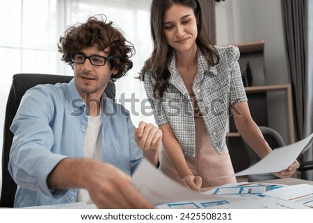 Caucasian businessman and Asia businesswoman working with color chart at office	