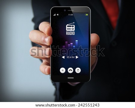 modern media concept: businessman holding a modern smartphone with radio app Royalty-Free Stock Photo #242551243