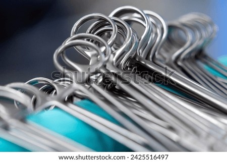 surgical instruments and tools including scalpels, forceps and tweezers arranged on a table for a surgery, Sterilized surgical instruments on the blue wrap Royalty-Free Stock Photo #2425516497