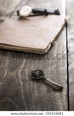  old book and a brass key on a vintage surface, close up