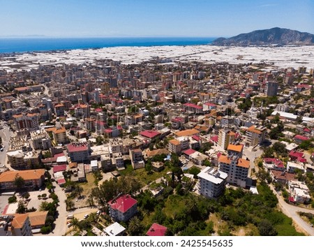 Picturesque aerial view of Turkish town of Anamur on Mediterranean coast overlooking many huge greenhouses on sunny spring day..