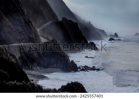 Powerful waves crash upon the beach along Pacific Coast Highway at the Pacific Ocean at Big Sur, California. Royalty-Free Stock Photo #2425557401