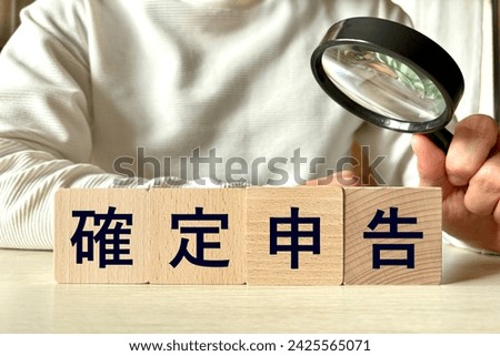 A man researching tax returns, translation: "Final tax returns" Royalty-Free Stock Photo #2425565071
