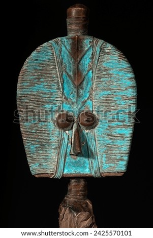 Close up of a wooden Kota reliquary figure from Gabon, isolated on a black background. Tribal African art, showcasing masterful craftsmanship and spiritual symbolism. Royalty-Free Stock Photo #2425570101