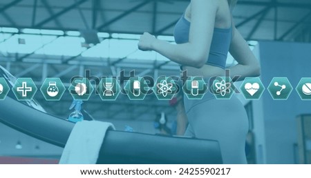 Multiple medical icons moving against woman wearing face mask running on treadmill at the gym. medical research and fitness concept