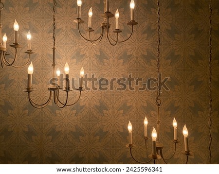 Candle chandelier against the backdrop of an antique patterned wall