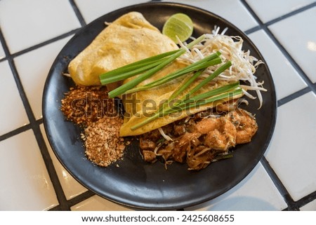 Pad Thai , Thai style noodles , pad thai with shrimp on  plate on wooden table ,top view, famous street food in Thailand Royalty-Free Stock Photo #2425608655