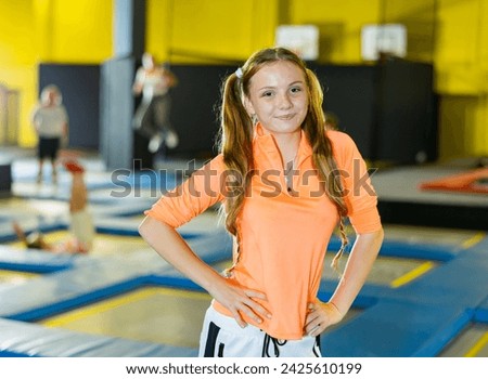 Smiling girl against the background of children playing in an amusement park