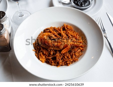 Appetizing racy seafood fideua with shrimps, mussels, scallops and fish served on plate with spicy aioli sauce. Authentic Valencian cuisine Royalty-Free Stock Photo #2425610639