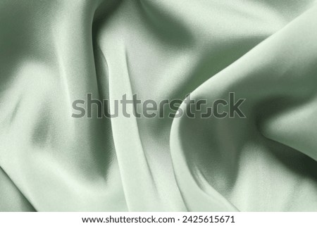 Texture of light green crumpled silk fabric as background, top view