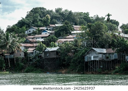 Some of the traditional dwellings on the banks of the Riam Kanan River in South Kalimantan and are neatly arranged in the middle of the hill. Royalty-Free Stock Photo #2425625937