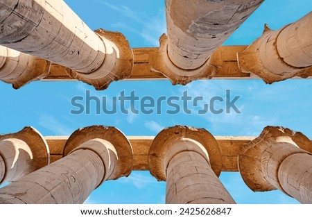 Different hieroglyphs on the walls and columns in the Karnak temple. Columns and blue sky in the great hypostyle hall at the Luxor temple, Egypt Royalty-Free Stock Photo #2425626847