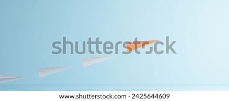 Leadership concept with orage paper plane leading among white on blue background.