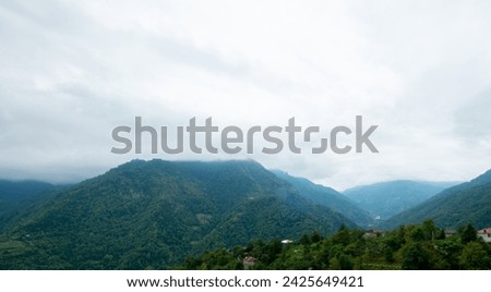 A village among green mountains with low clouds
