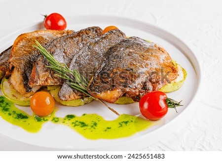 fried fish with vegetables on plate Royalty-Free Stock Photo #2425651483