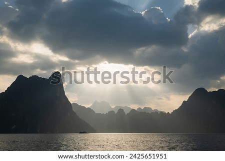 A beautiful sunset against the backdrop of karst mountains, view from Khao Sok Lake, Thailand.