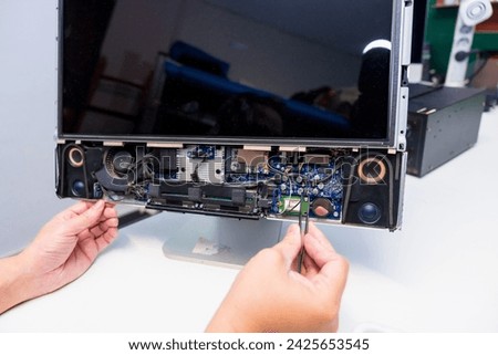 Close-up of the hands of a IT Engineer repairing a computer in a workshop