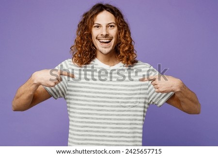 Young smiling happy fun man he wears grey striped t-shirt casual clothes point index finger on himself look camera isolated on plain pastel light purple background studio portrait. Lifestyle concept