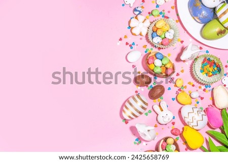 High-colored Easter baking background, Easter sale, party invitation flat lay, Colorful Easter eggs, chocolate eggs and bunny rabbit with sugar sprinkles on bright pink background top view copy space