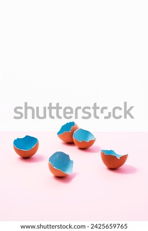 Blue painted easter eggs shells on pink, and white background